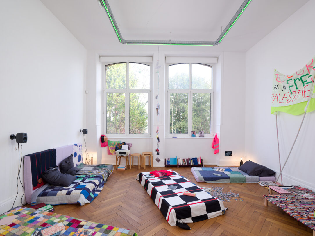 Katja Mater, Clare Noonan, Jessica Gysel, Marnie Slater, Robin Brettar, Matilda Çobanli, Common Room [Salle commune], 2025. Archives, goodies queer, trésors familiaux, objets d’art, livres, marque-pages, bibelots, lampes en bois réemployé, ampoules. Courtesy des auteur·ices. Production CRAC Alsace. Photo A. Mole